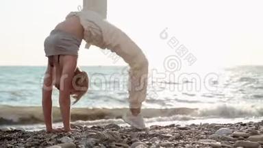 一位身材矮小、运动力强的海边女子仰着腰，背起身来，双手放在地板上，锻炼身体以保持身体健康